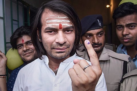 RJD leader Tej Pratap shows his inked finger at a polling station after casting his vote
