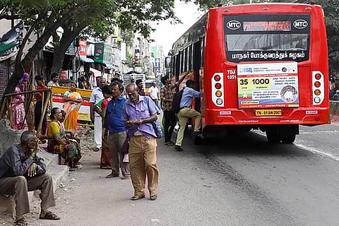 Commuters wait at the spot where the old shelter was pulled down