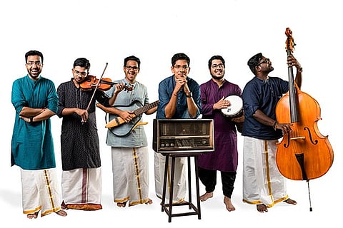 Members of Staccato dressed in veshti, holding violin, bass guitar, double bass