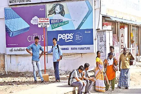 Students and other commuters waiting for bus in the sun