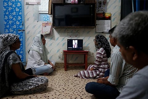 A family attends a live broadcast of a mass inside their house on Good Friday (Courtesy: Reuters)
