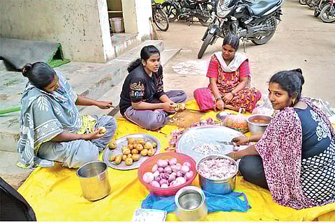 Family members of policemen in TP Chathiram quarters cutting vegetables to make food