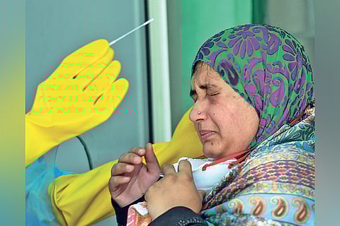A doctor takes swab from a woman at a Walk-In Sample Kiosk (WISK) in a government hospital, Chennai