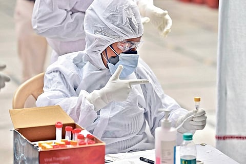 A health worker collect swab samples from people for COVID-19 tests