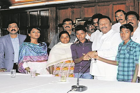 Forest Minister Dindigul Sreenivasan apologising to the tribal boy in Ooty on Friday