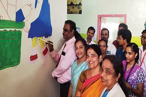 CMCH Dean Dr B Ashokan tries his hand at adding colours to the paediatric ward of the hospital on Wednesday