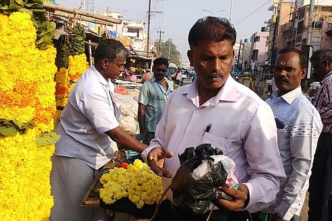 Corporation officials seizing banned plastics and other items from the Nethaji flower market