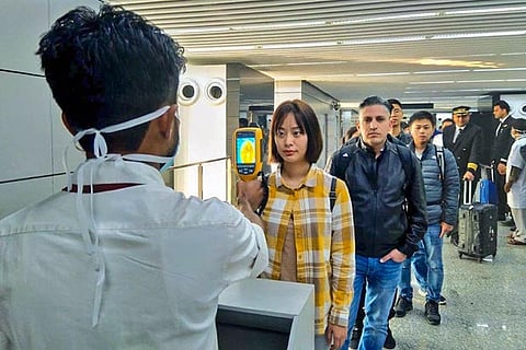 A thermal screening device checks passengers arriving from?China at an airport in Kolkata
