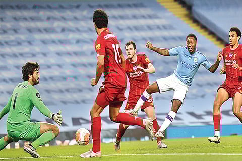 Manchester City forward Raheem Sterling (in blue) slots the ball home
