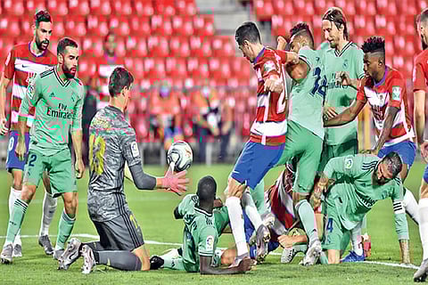 Real Madrid players attempt to block a shot on goal from Granada