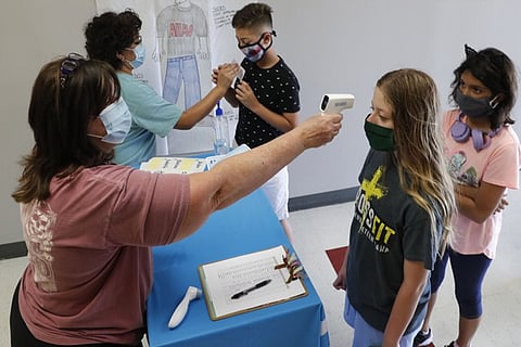 Teachers check students before a summer STEM camp at Wylie High School in Wylie, Texas.