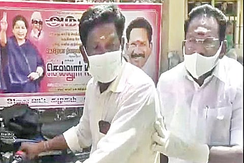 Raju, traveling pillion on a AIADMK man?s bike to a PDS shop at Bethaniyapuram in Madurai on Monday
