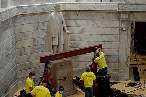 Workers prepare to remove a statue of Confederate President Jefferson Davis
