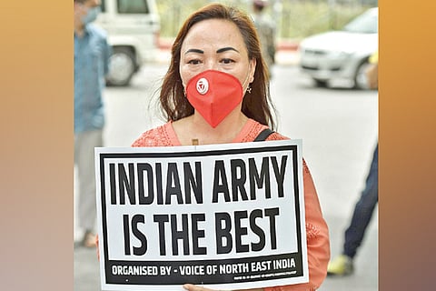 Member of Voice of Northeast India holds a placard during a protest against China
