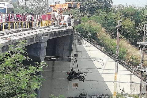 Police using crane to lift the two-wheeler from railway track