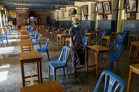 A sanitation staff disinfecting examination hall