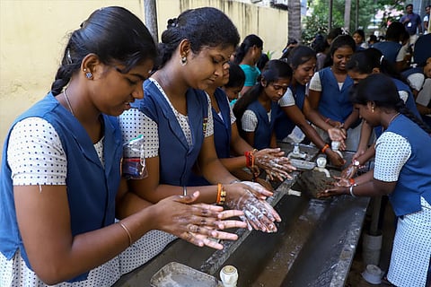Students washing hands before entering exam halls on Friday