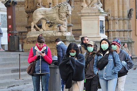 People wearing protective masks walk through Florence, Italy (File Photo: Reuters)