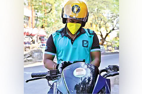 An executive of a popular app waits for orders in Chennai on Sunday