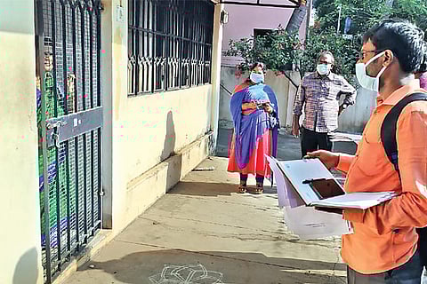 A Corporation staffer inspects a house in a neighbourhood where a positive case was reported
