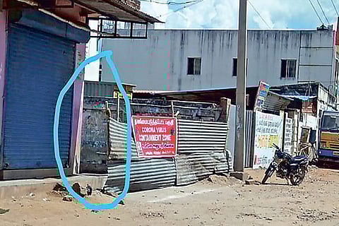 The gap between the wall and metal barricade through which residents sneak out of the containment