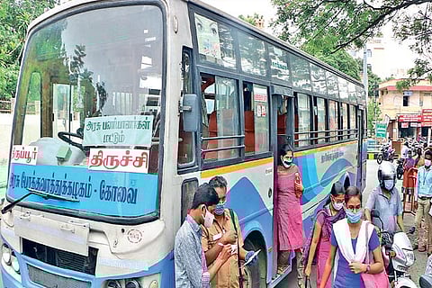 Passengers alight from a bus as public transport resumed in Coimbatore on Monday after several weeks
