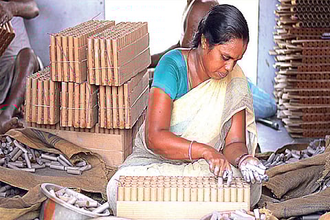 A worker making crackers at a manufacturing unit in Sivakasi