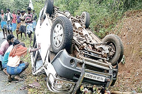 Locals take a look at the capsized car in Erode on Sunday