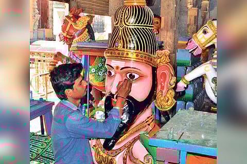 An artisan giving final touches to a vahanam.