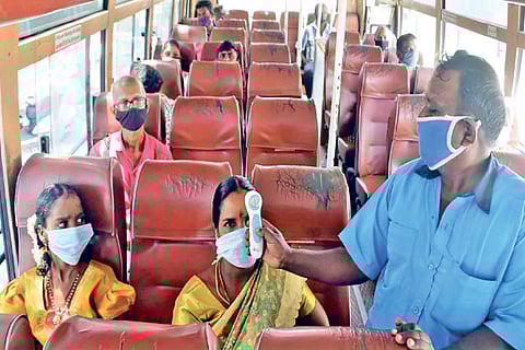 A conductor does thermal testing of a passenger in Coimbatore