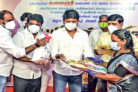 Udhayanidhi distributing relief materials to a woman in Chennai
