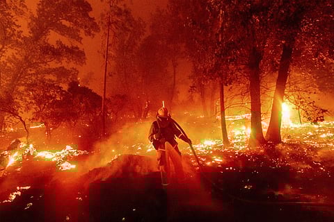 A firefighter battles the Creek Fire as it threatens homes in the Cascadel Woods