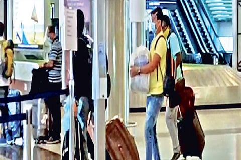 A passenger carries luggage in his hands at airport