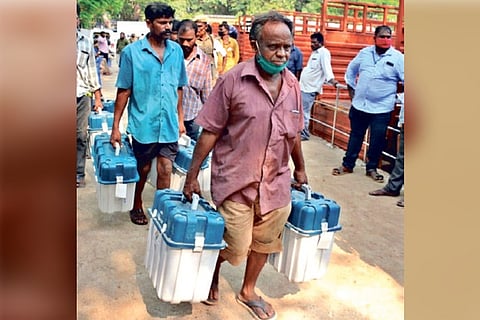 Workers carrying voting machines to a polling booth in Ambattur on Monday