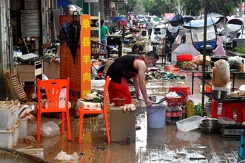 People sort items after heavy rainfall brought by Typhoon Lupit, shops in Nanyu town(Image: Reuters)