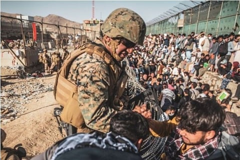 A US Marine helps in the evacuation process at Kabul airport (Source: Reuters)