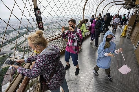 Visitors enjoy the view from top of the Eiffel Tower in Paris (file photo)