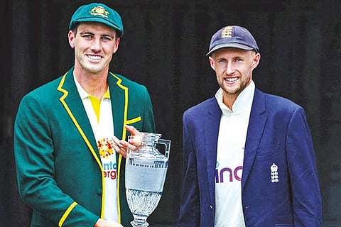 Pat Cummins (left) and Joe Root pose with the Ashes trophy