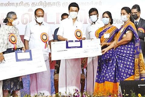 Stalin distributing loan to a self-help group (SHG) member in Tiruttani on Tuesday