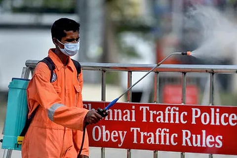 A health worker sprays disinfectants in a parking area in Chennai (Image credit: PTI)