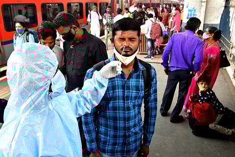 A health worker takes swab sample from a man (Credits: PTI)
