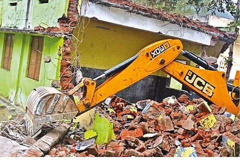 An earthmover clearing debris of a demolished school building in Tiruvannamalai