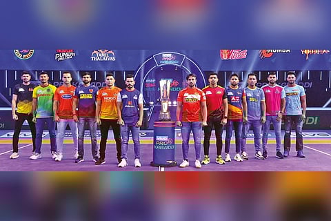 Captains of the 12 teams pose with the Pro Kabaddi League trophy