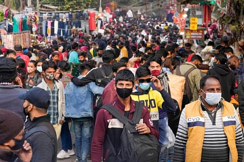People walking in a crowded street all masked up