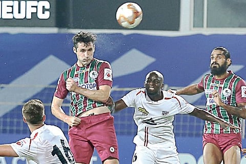 Carl McHugh attempts an header with NEUFC defenders looking on.