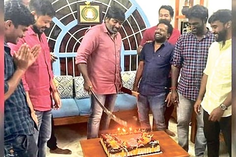 Sethupathi cutting the cake with a machete