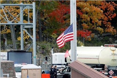 US Custom officers seen speaking with a person at Canada-US border (Credit: Reuters)