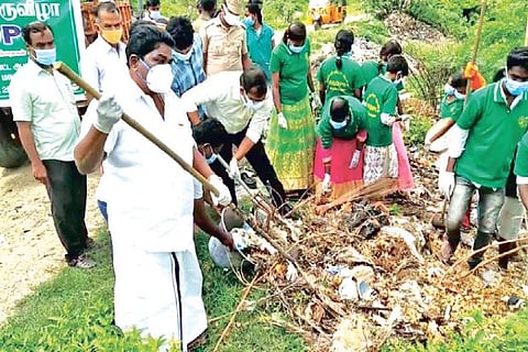 Tirupattur Collecter Amar Kuswaha and officials clearing garbage in the town on Friday
