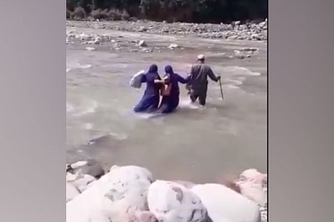 Healthcare workers in Jammu and Kashmir's Rajouri crossing a river to conduct COVID-19 vaccination