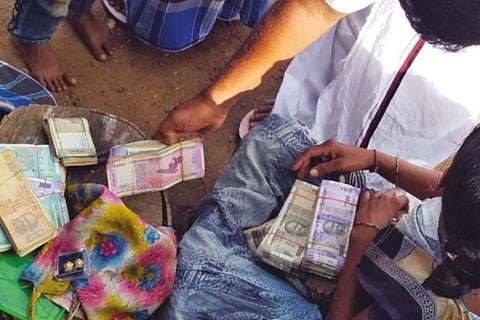 Local residents of Kurumalai near Anaicutchecking the cash and jewels returnedby policemen on Wednes